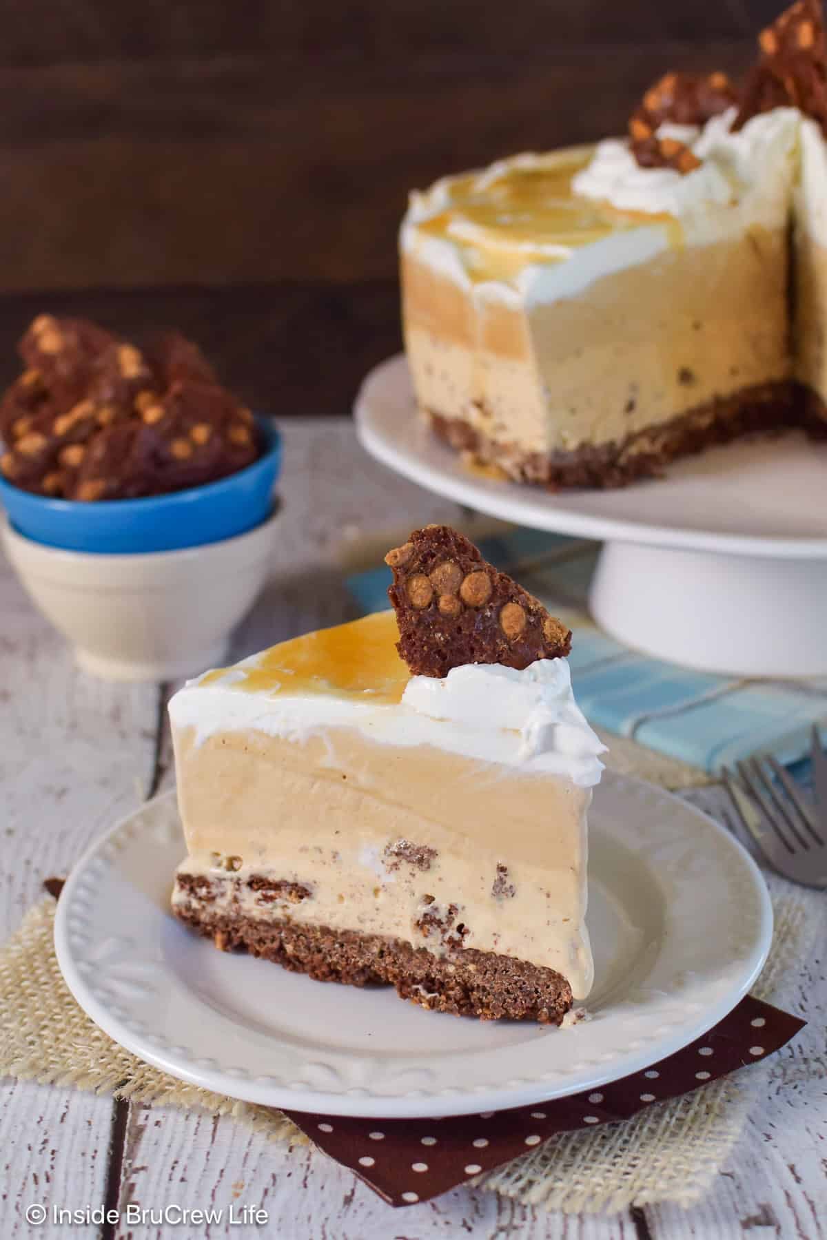 A slice of caramel ice cream cake with a brownie brittle crust on a white plate.