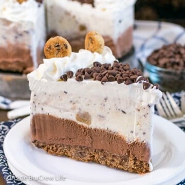 A white plate with a slice of chocolate chip cookie dough ice cream cake on it