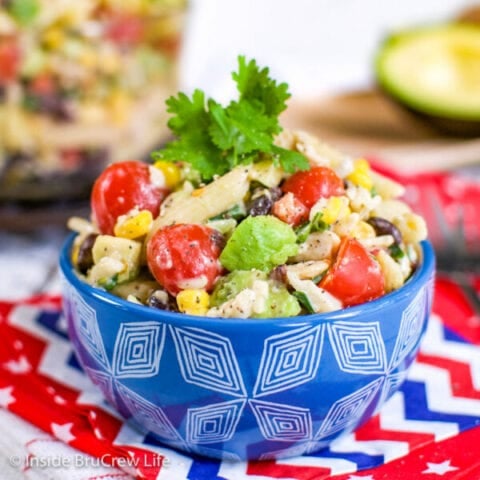 A blue bowl filled with ranch pasta salad loaded with veggies