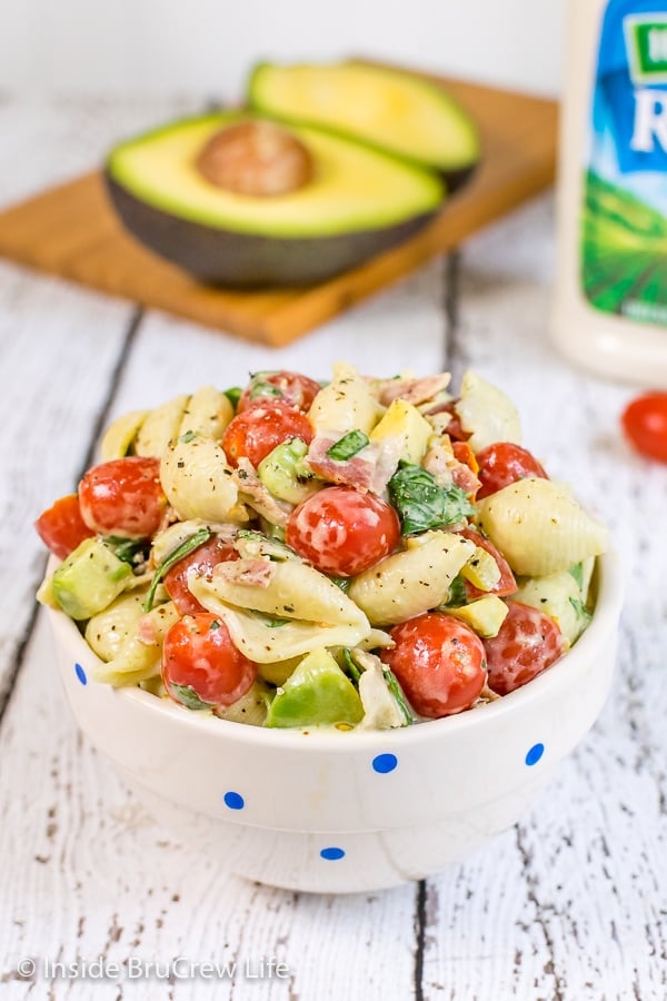 A white bowl on a white background filled with ranch BLT pasta salad