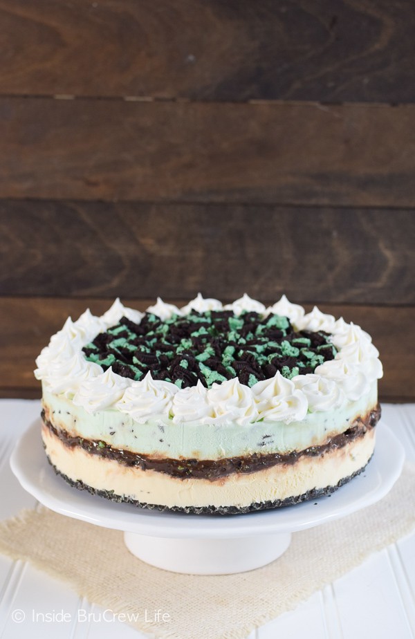 A picture of a whole Vanilla Mint Chip Ice Cream Cake topped with whipped cream and Oreo cookie chunks