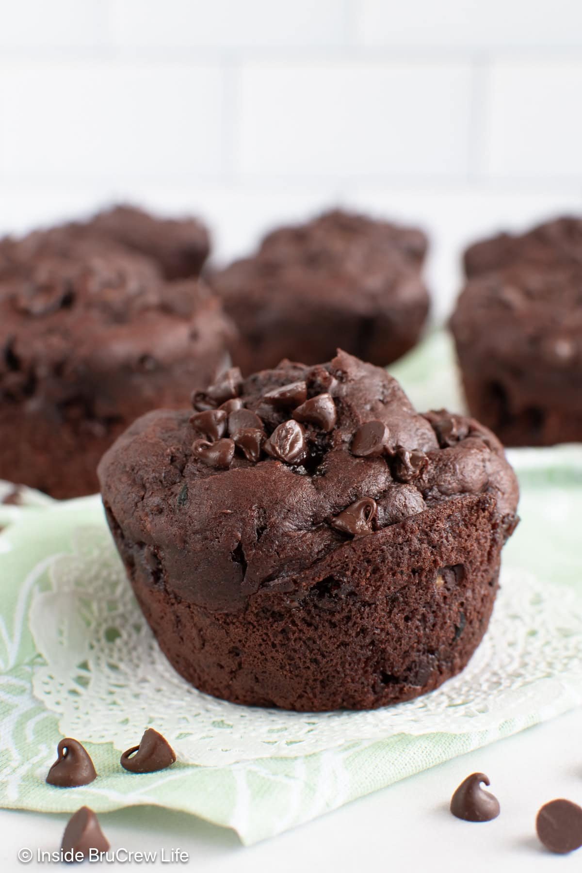 Chocolate zucchini muffins on a white board.