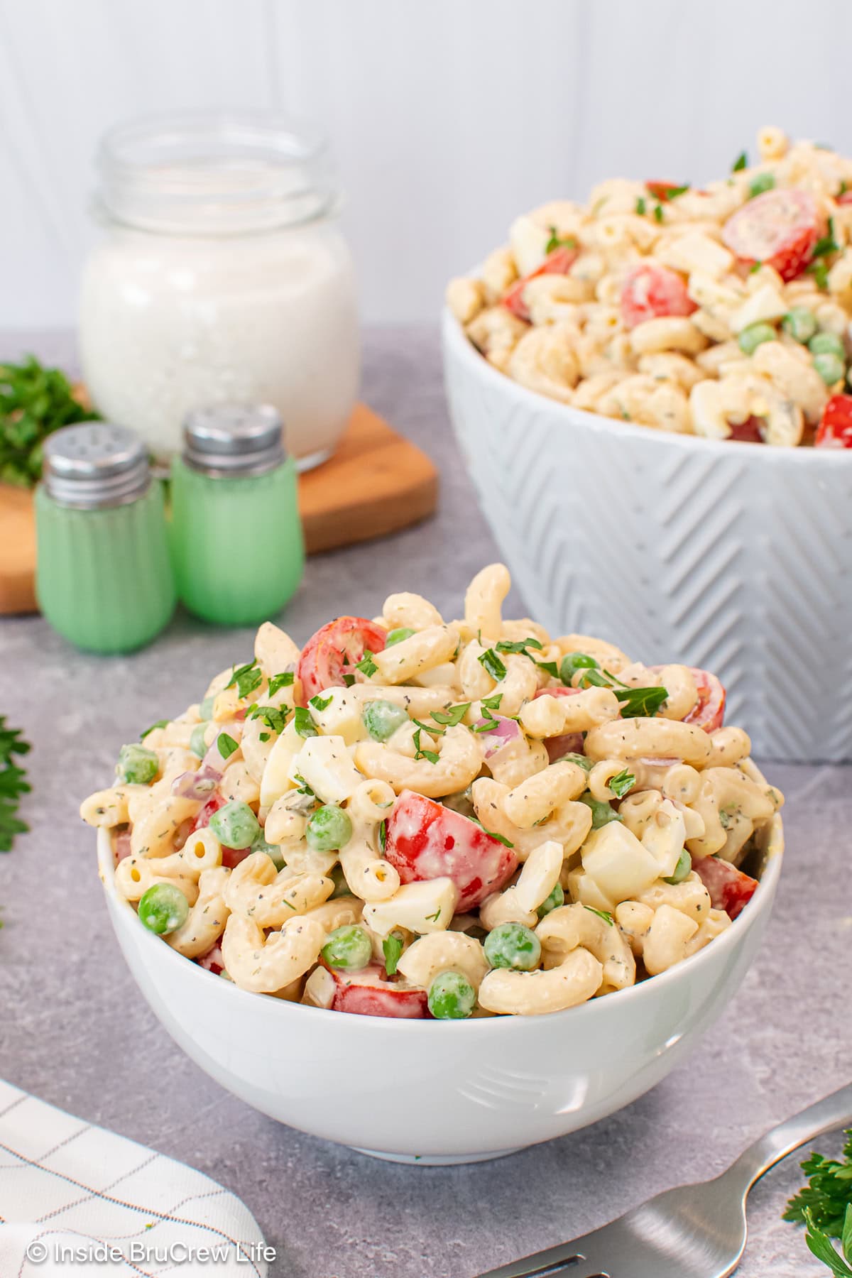 A white bowl filled with a summer pasta salad.