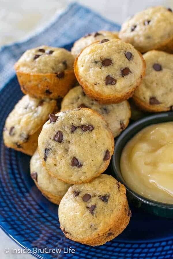 A blue plate filled with pancake muffins and a bowl of honey butter