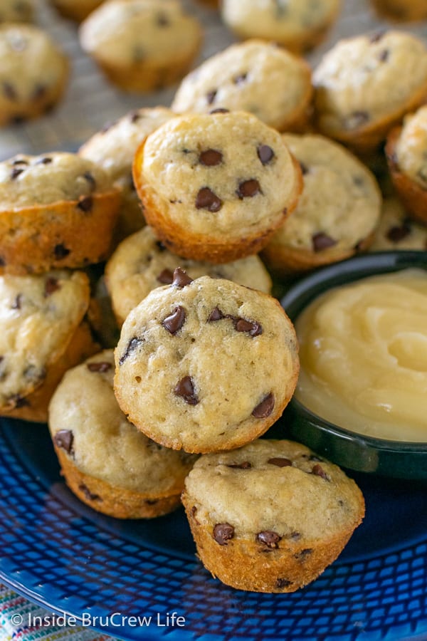 Mini pancake muffins on a blue plate with a bowl of honey butter