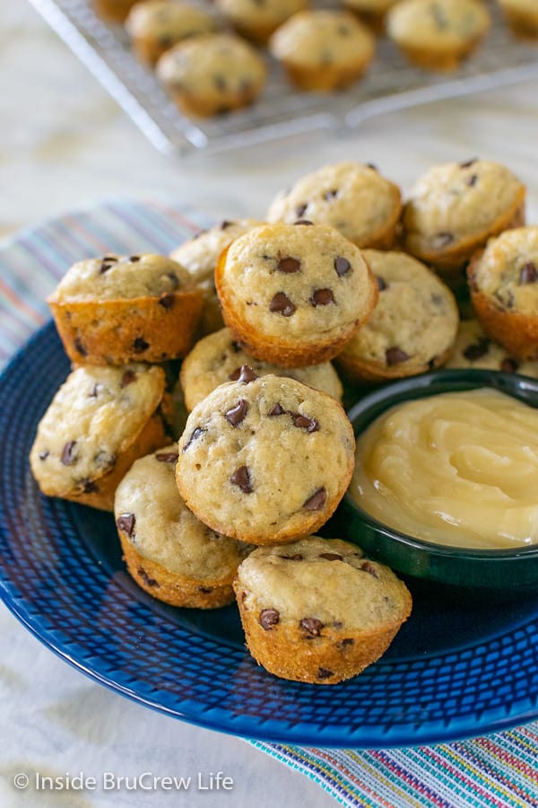 A blue plate filled with mini pancake muffins and a bowl of honey butter