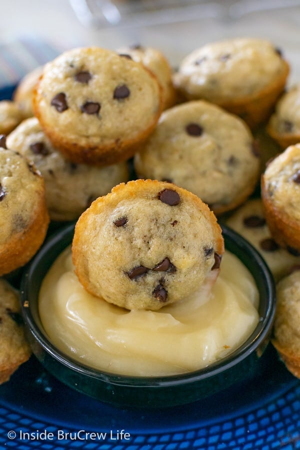 A close up picture of a mini pancake muffin in a bowl of honey butter