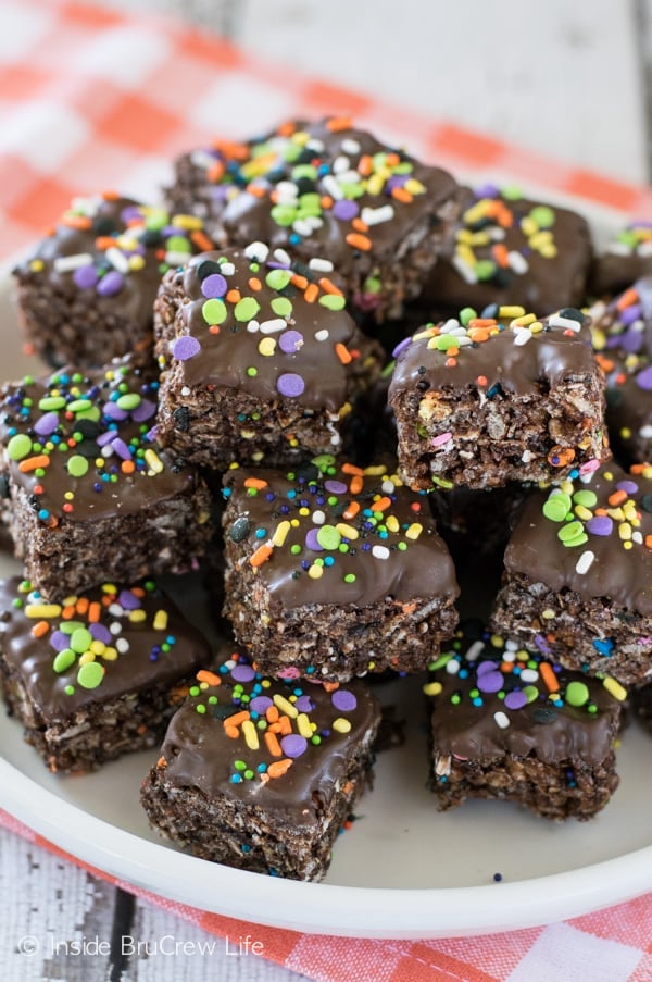 A white plate filled with no bake chocolate granola bar bites stacked on it