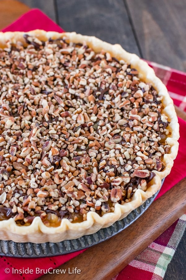 Overhead picture of a caramel apple tart topped with chocolate and pecans.