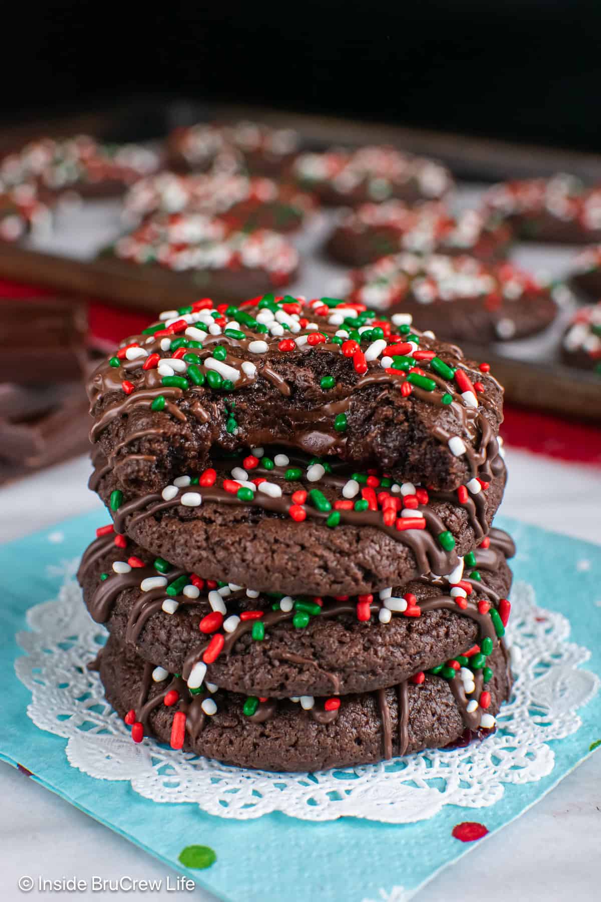 Stacked chocolate Christmas cookies with a bite out of the top showing the molten center.