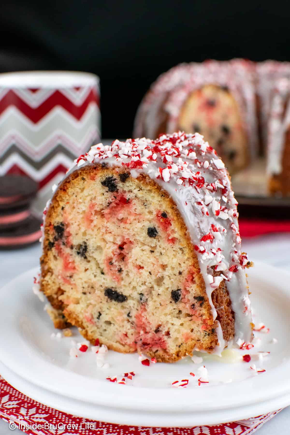 A large slice of a peppermint bundt cake on a white plate.