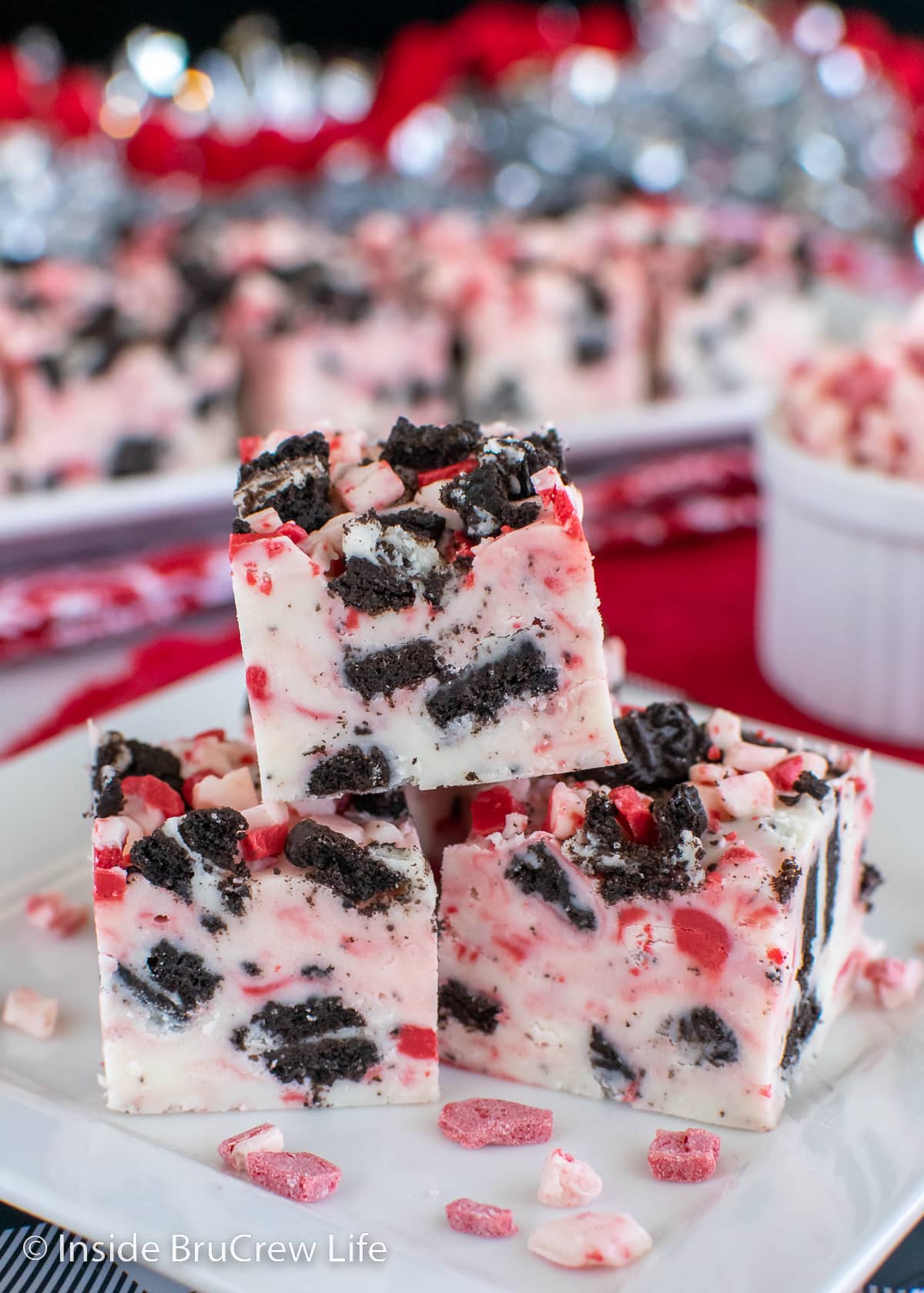 A stack of peppermint cookie fudge stacked on a plate.