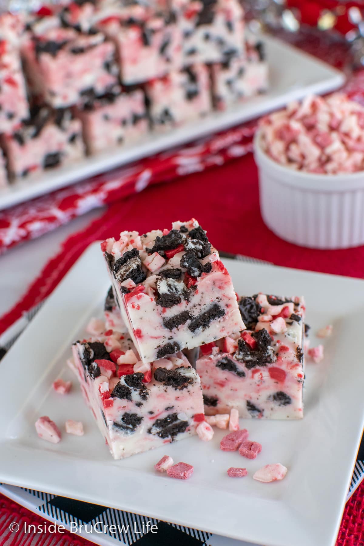 Squares of peppermint fudge stacked on a white plate.
