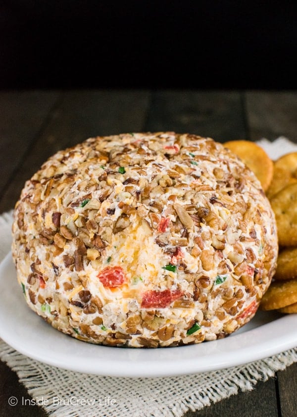 A red pepper cheeseball on a white plate.