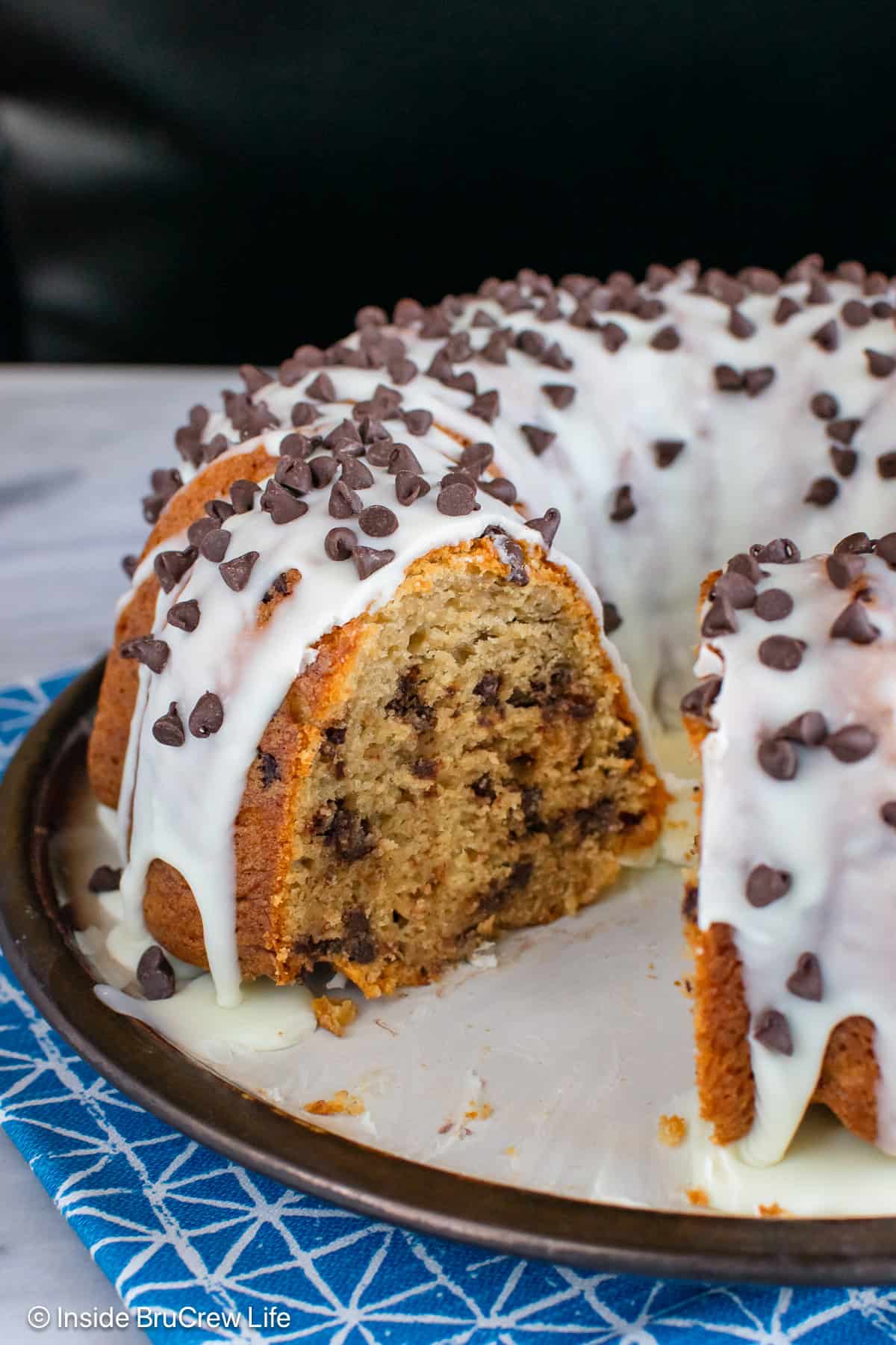 A coffee flavored bundt cake on a plate topped with white chocolate glaze.