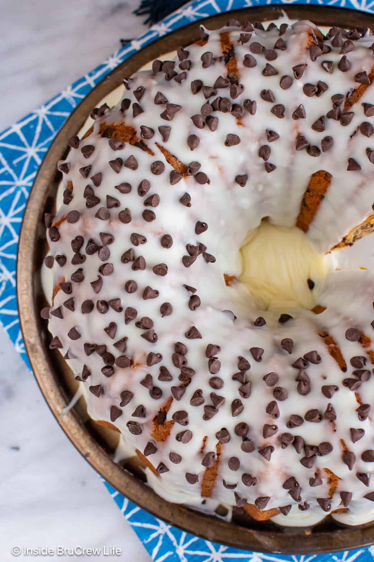 The top of a bundt cake covered in white chocolate glaze.