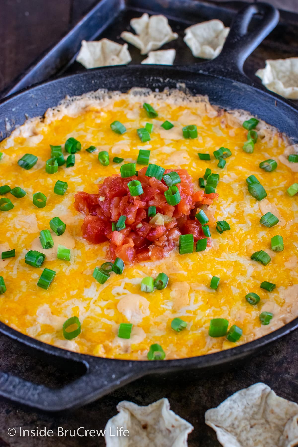 Close up of a melted cheesy corn dip in a skillet.