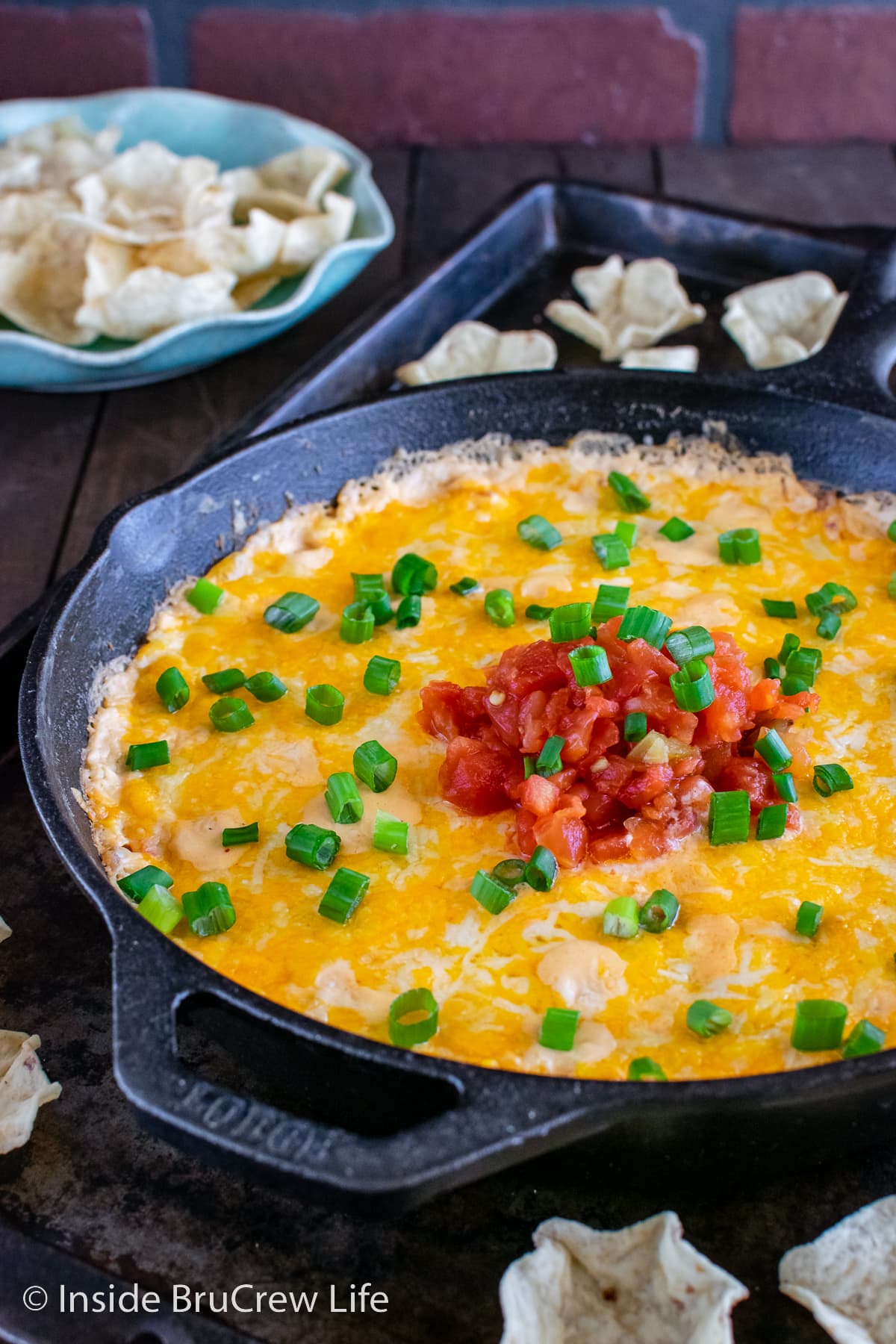 A cast iron skillet filled with a melted hot corn dip.