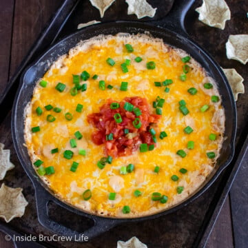 A cast iron skillet filled with a cheesy hot corn dip.