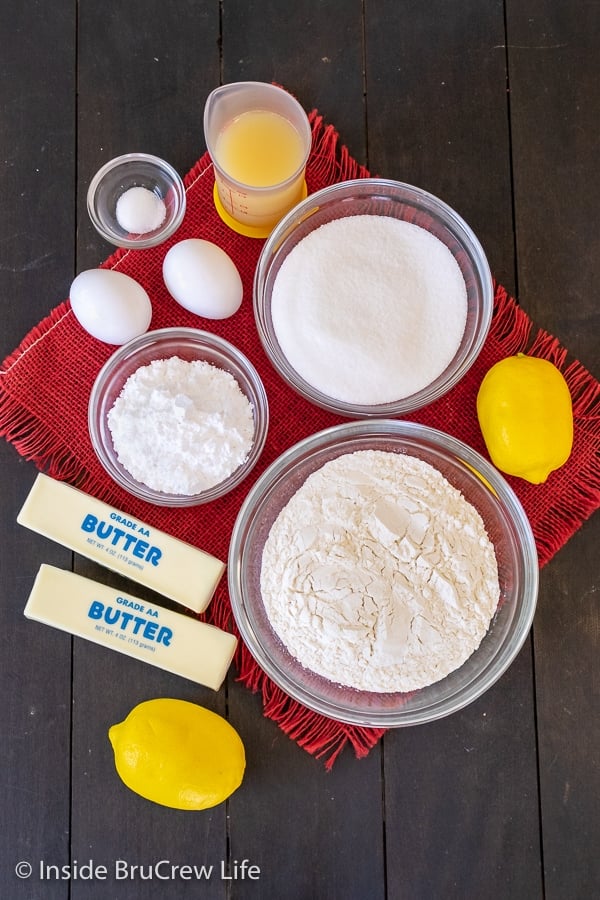 A wooden board with bowls of ingredients to make cookie bars.