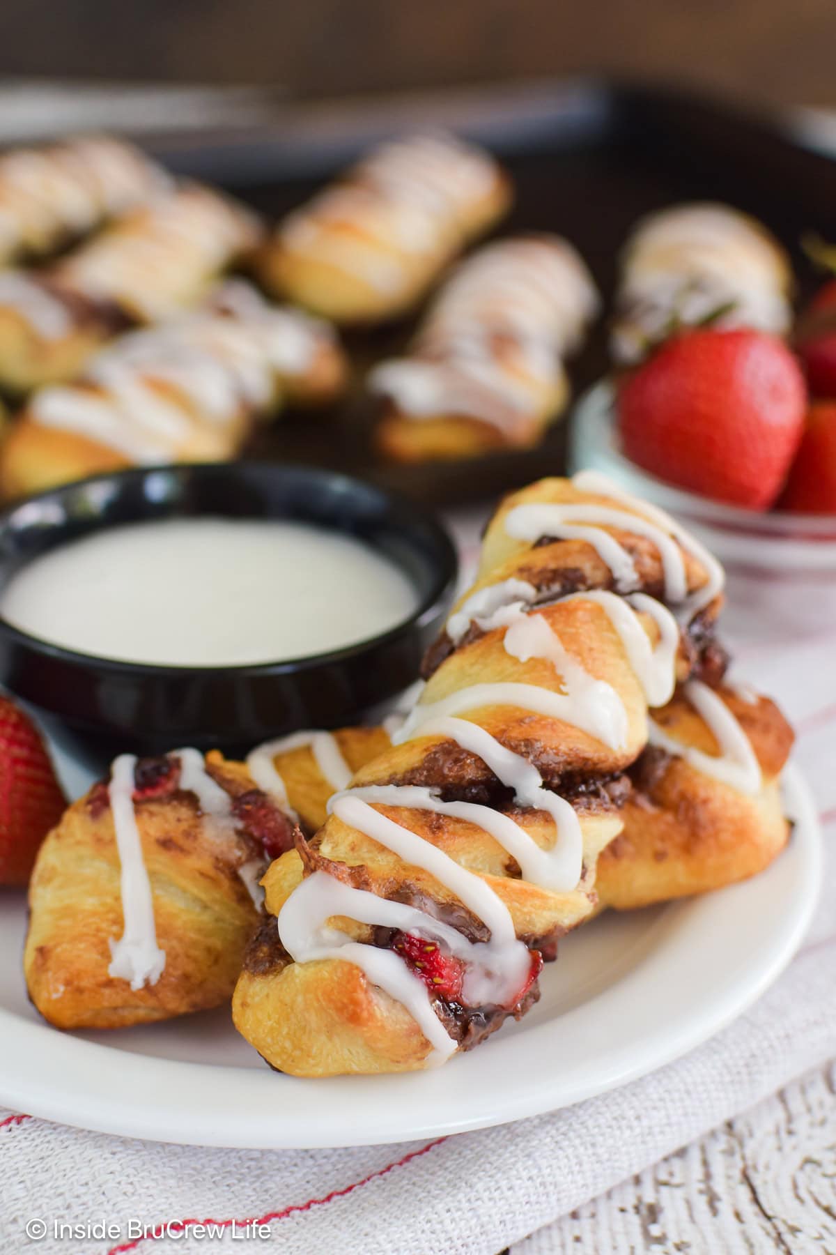 Strawberry hazelnut pastry rolls on a white plate.