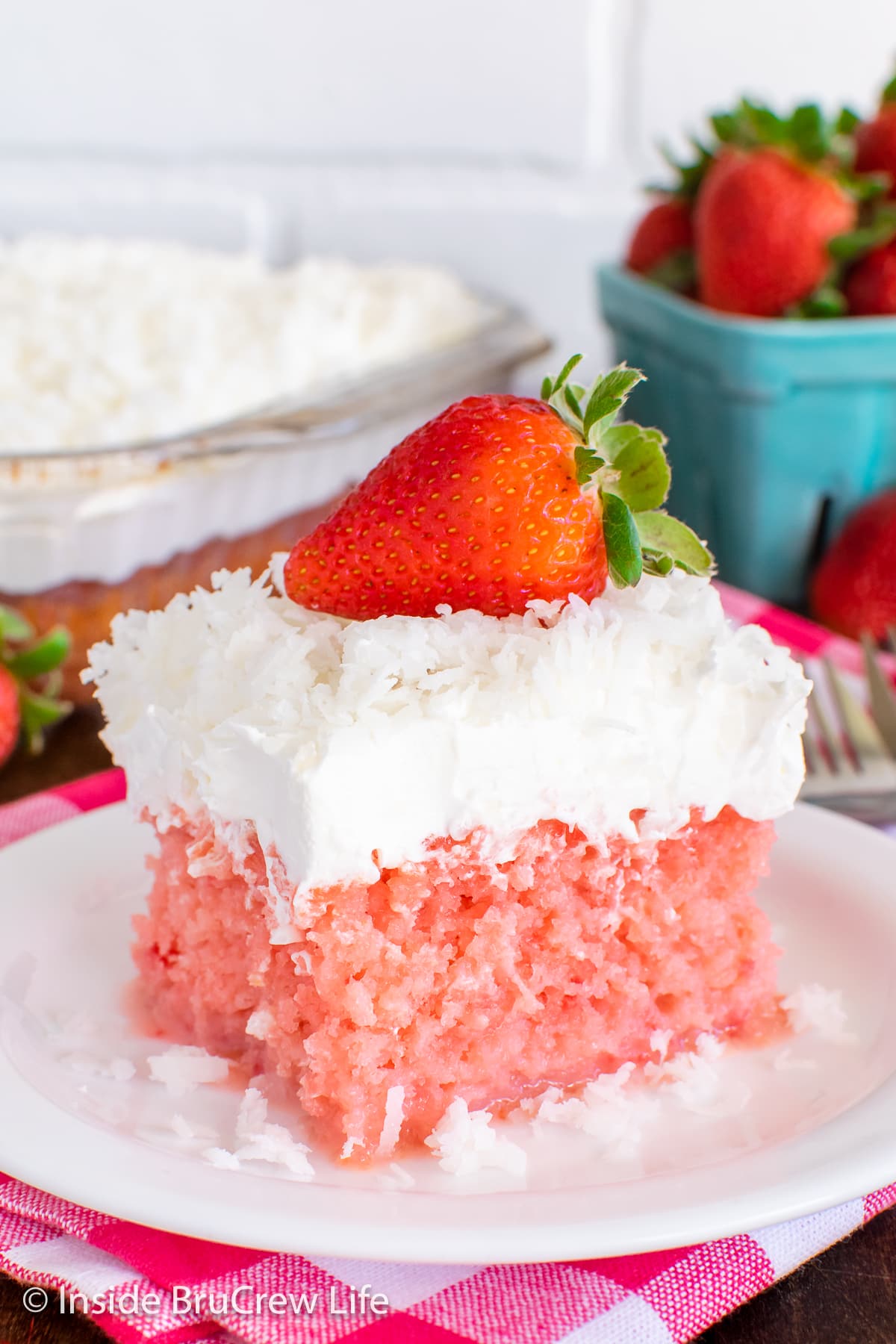 A slice of strawberry cake with sweetened condensed milk topped with Cool Whip.