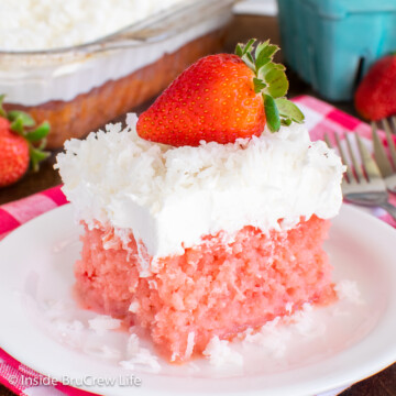 A slice of strawberry poke cake topped with Cool Whip and shredded coconut.