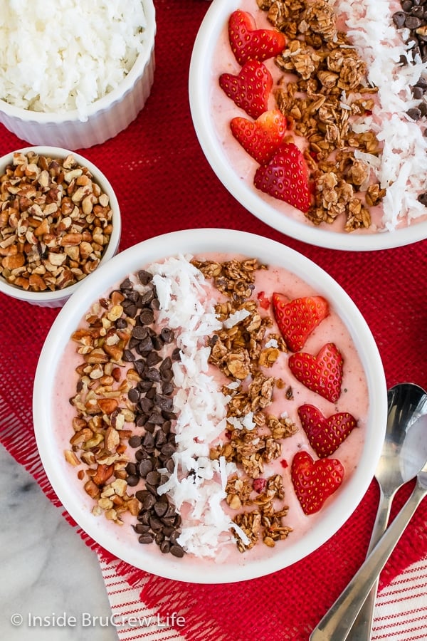 A white bowl filled with a pink smoothie and toppings.