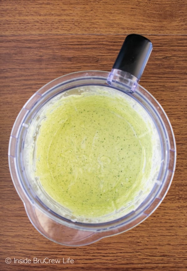 A blender filled with a mixed avocado lime ranch dressing in it.
