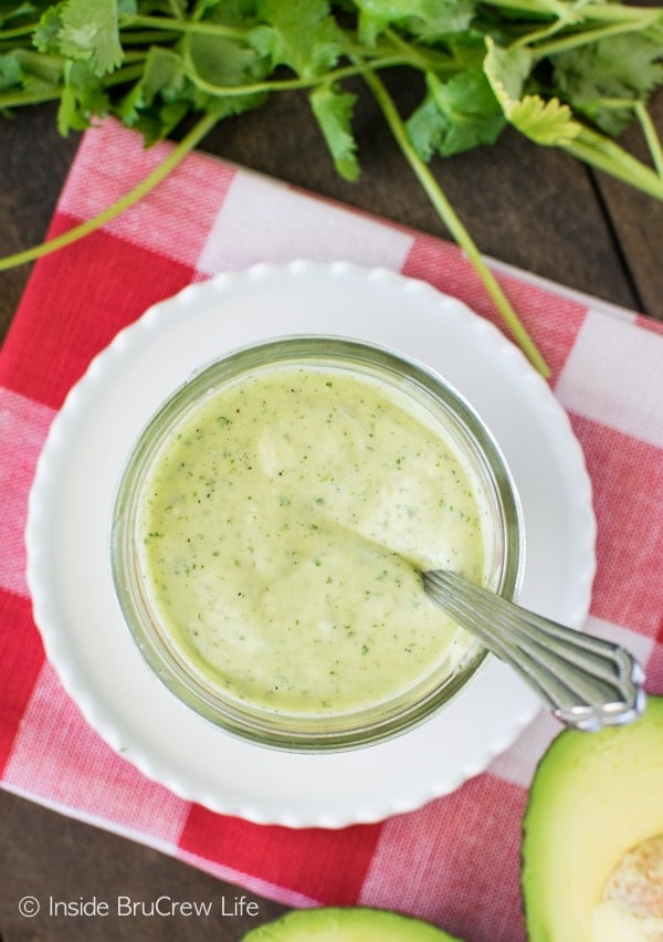 Overhead picture of a jar filled with green avocado lime ranch salad dressing.