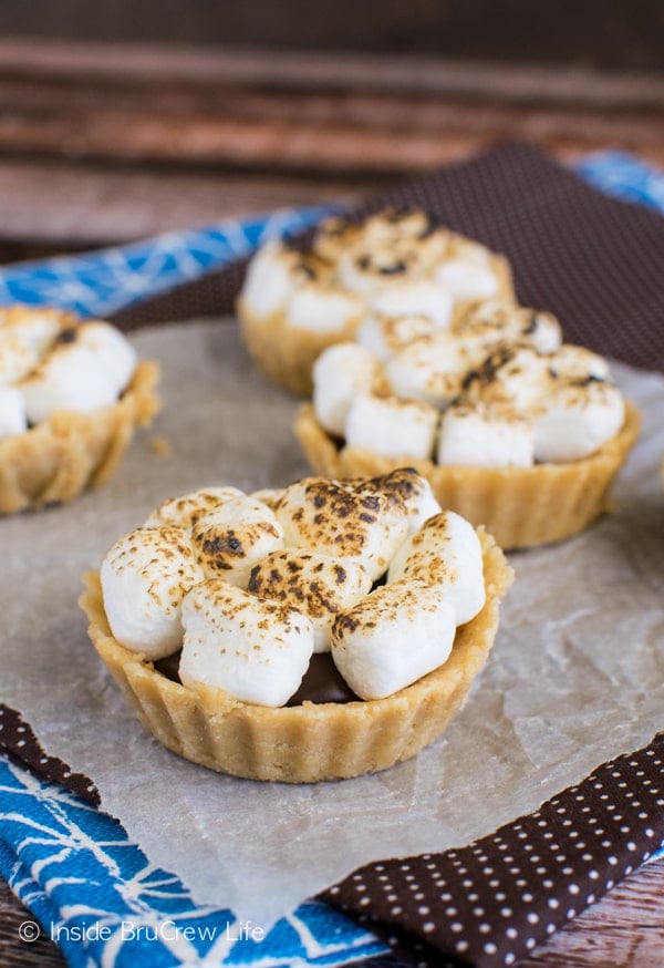Mini S'mores Pies with toasted marshmallows on parchment paper
