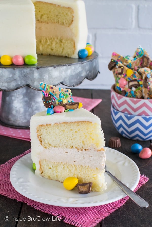 A slice of white cake with white frosting topped with colorful Easter candies.