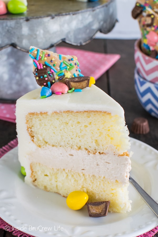 A slice of white cake with white frosting topped with colorful Easter candies.