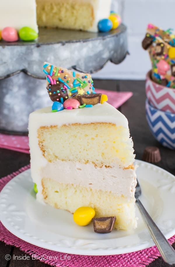 A slice of white cake with white frosting topped with colorful Easter candies.