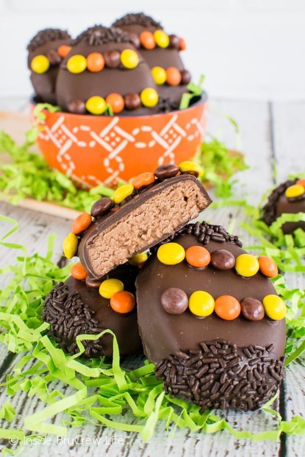 Three Reese's eggs stacked on top of each other with the top one cut in half showing the inside filling.