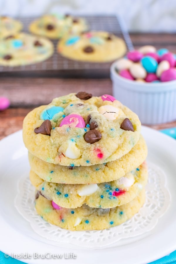 A white plate with a stack of vanilla pudding cookies loaded with chocolate chips, candy, and sprinkles