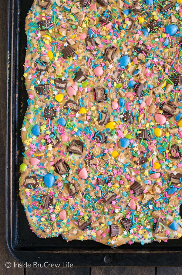 A pink and blue bowl full of peanut butter and chocolate bark loaded with Easter sprinkles.