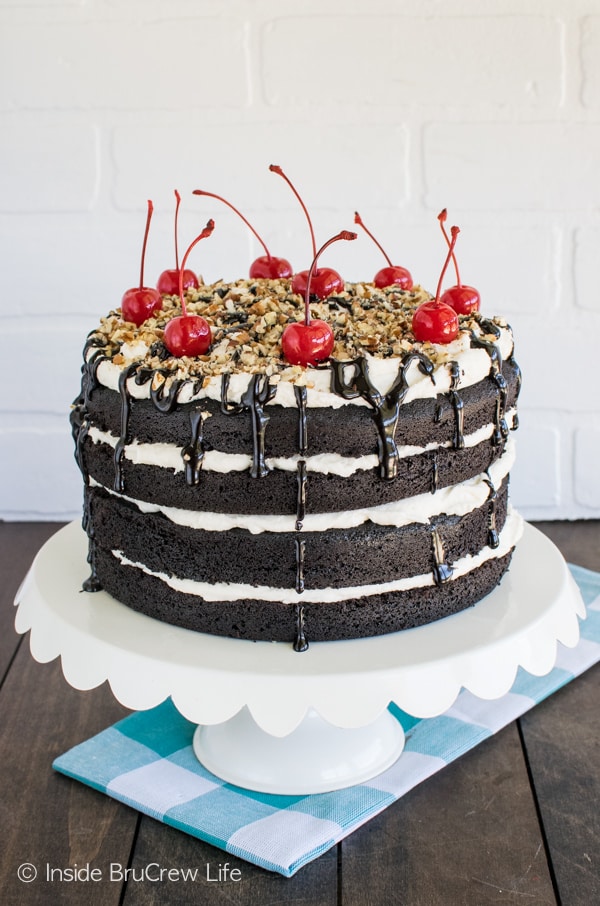 Cherries, pecans, and hot fudge add a fun topping to this Dark Chocolate Layer Cake. This is an absolutely perfect dessert recipe.