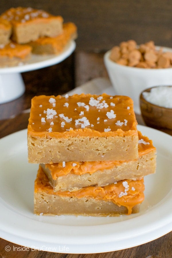 Three salted butterscotch bars stacked on a white plate