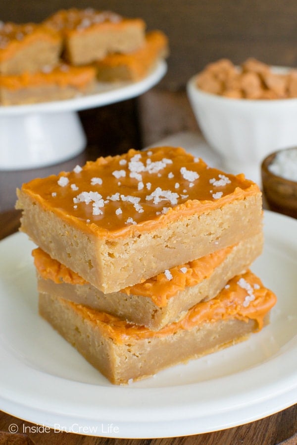 Three salted butterscotch bars stacked on a white plate