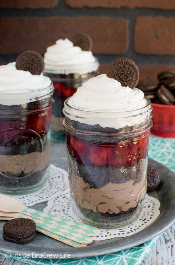 Layers of cookies, cherry pie filling, and chocolate cheesecake make these Cherry Chocolate Mousse Parfaits a fun summer treat. Great no bake recipe!