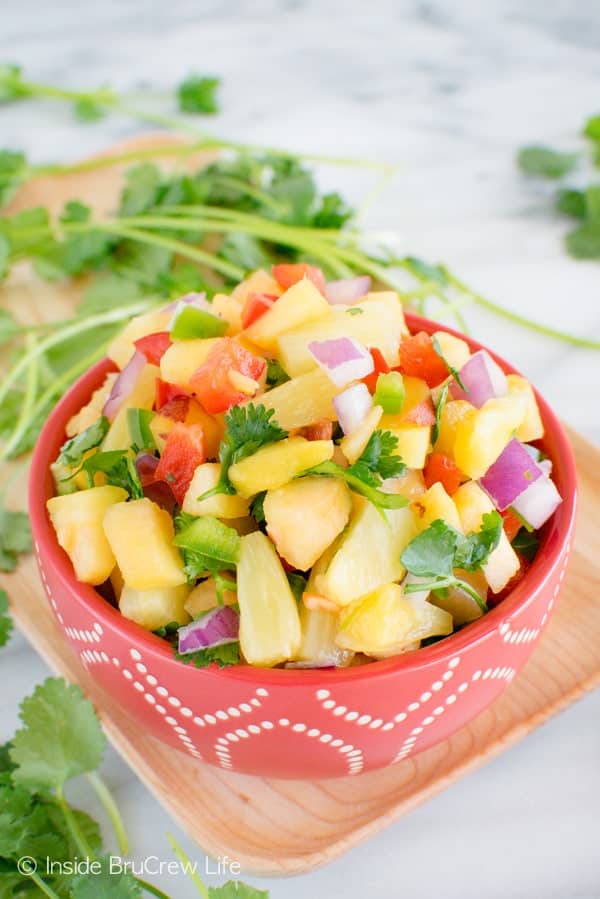 A red bowl full of pineapple peach salsa.