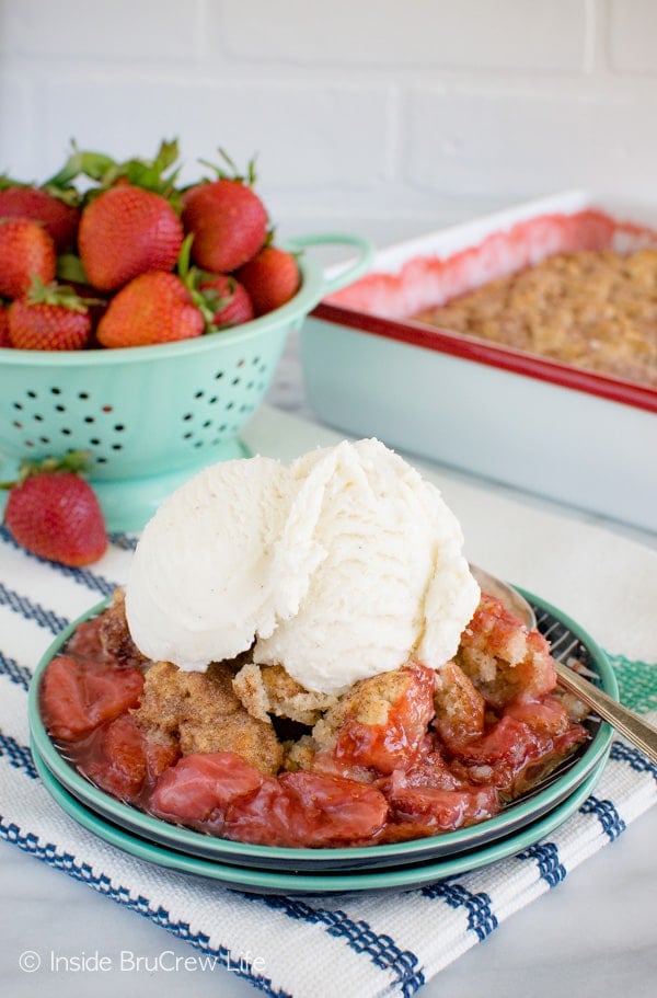 A plate filled with strawberry cobbler and topped with vanilla ice cream