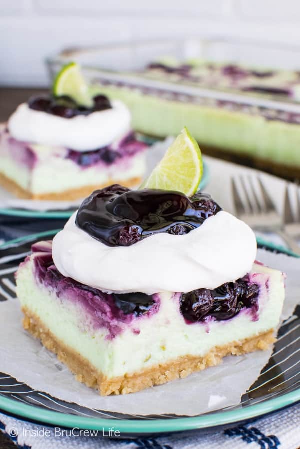 Blueberry Key Lime Cheesecake Bars - these creamy cheesecake bars are loaded with blueberry pie filling and citrus flavor. Awesome summer dessert recipe! #cheesecake #blueberry #piefilling #cheesecakebars #keylime #summerdesserts