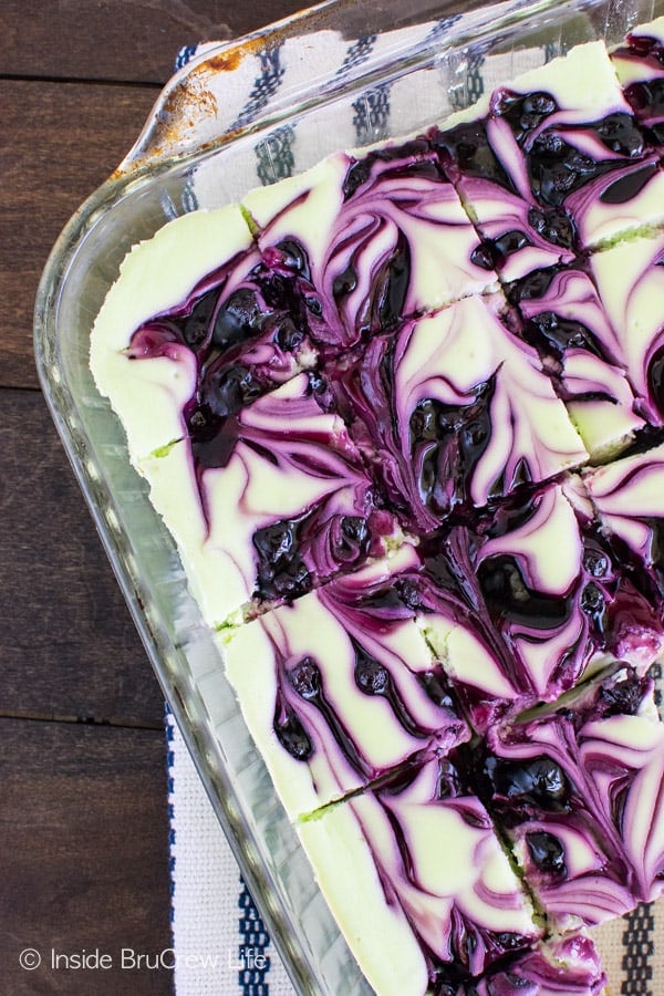 Blueberry Key Lime Cheesecake Bars - swirls of blueberry pie filling make these cheesecake bars the perfect summer dessert. Make this easy recipe for picnics and parties! #cheesecake #blueberry #piefilling #cheesecakebars #keylime #summerdesserts