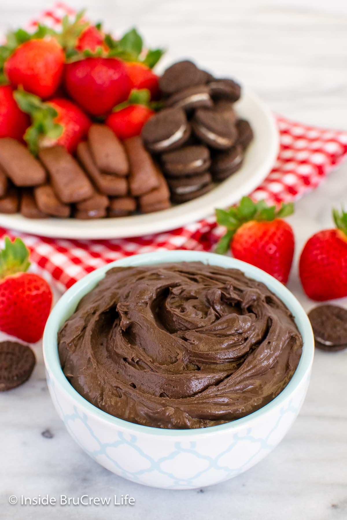 A white bowl with chocolate cream cheese dip in it.