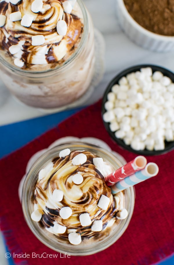 Overhead pictures of two glasses of Frozen Salted Caramel Mocha Hot Chocolate drizzled with caramel and chocolate