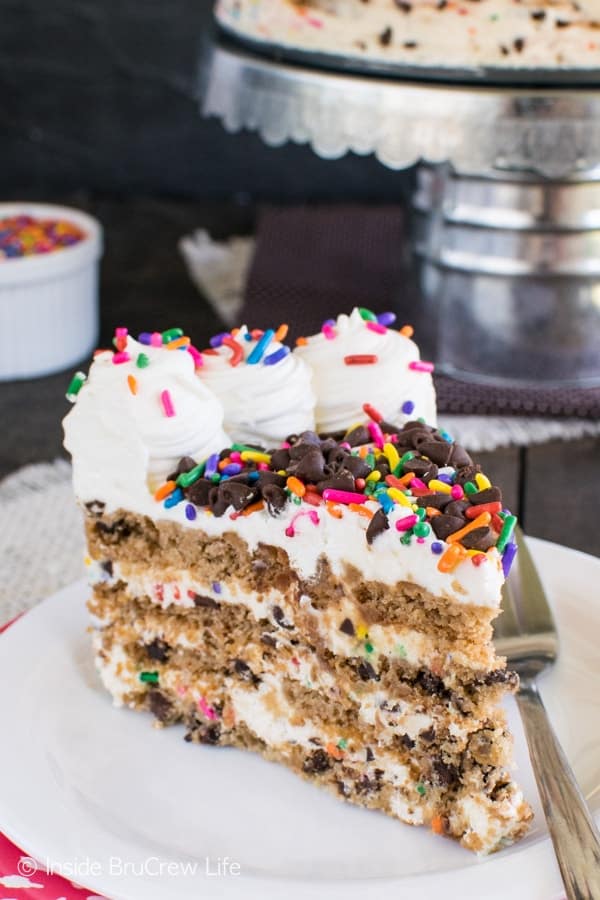 A slice of no bake icebox cake topped with whipped cream and sprinkles.
