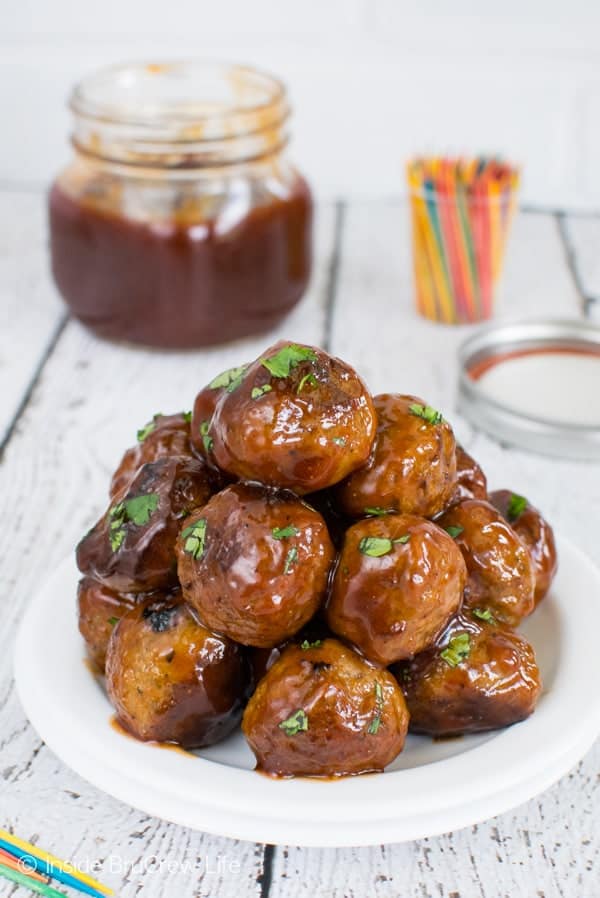 A white plate with a stack of meatballs covered in honey sriracha barbecue sauce