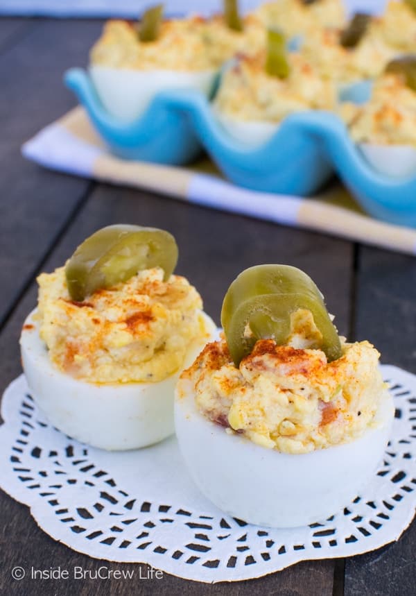 2 loaded deviled eggs on a white doily.